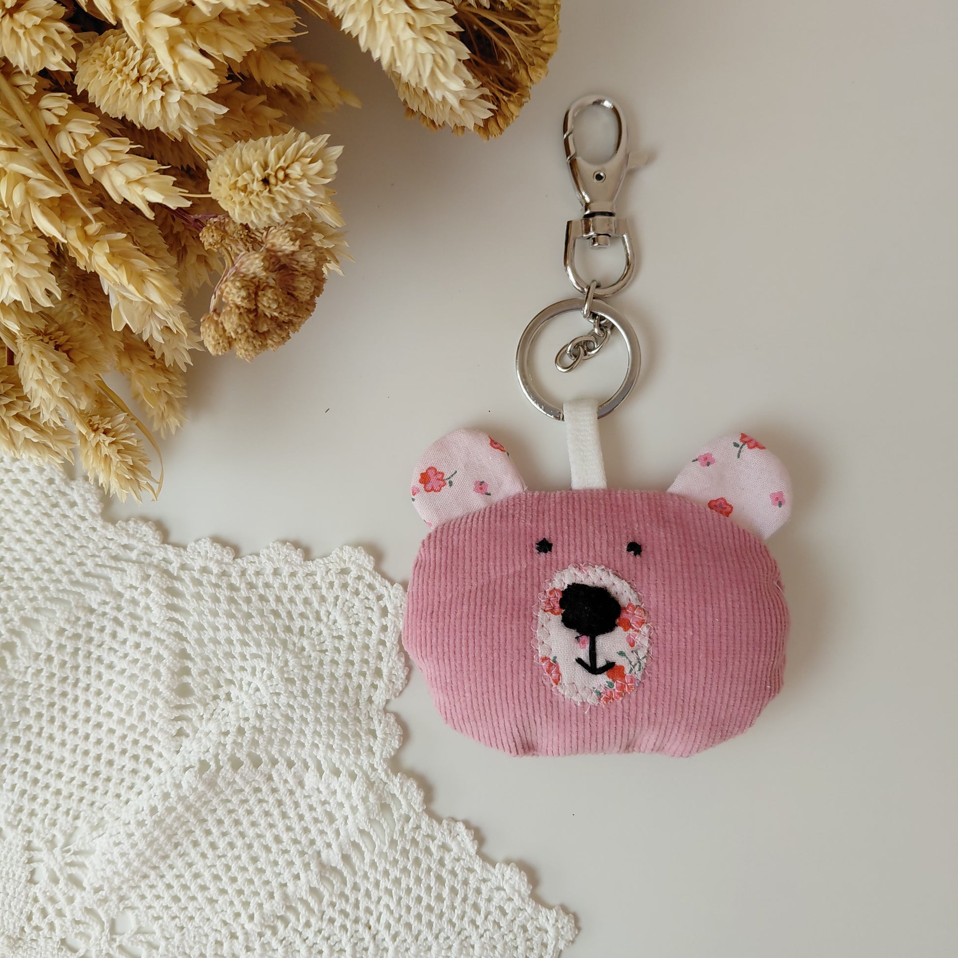 Pink bear-shaped keychain with floral details 