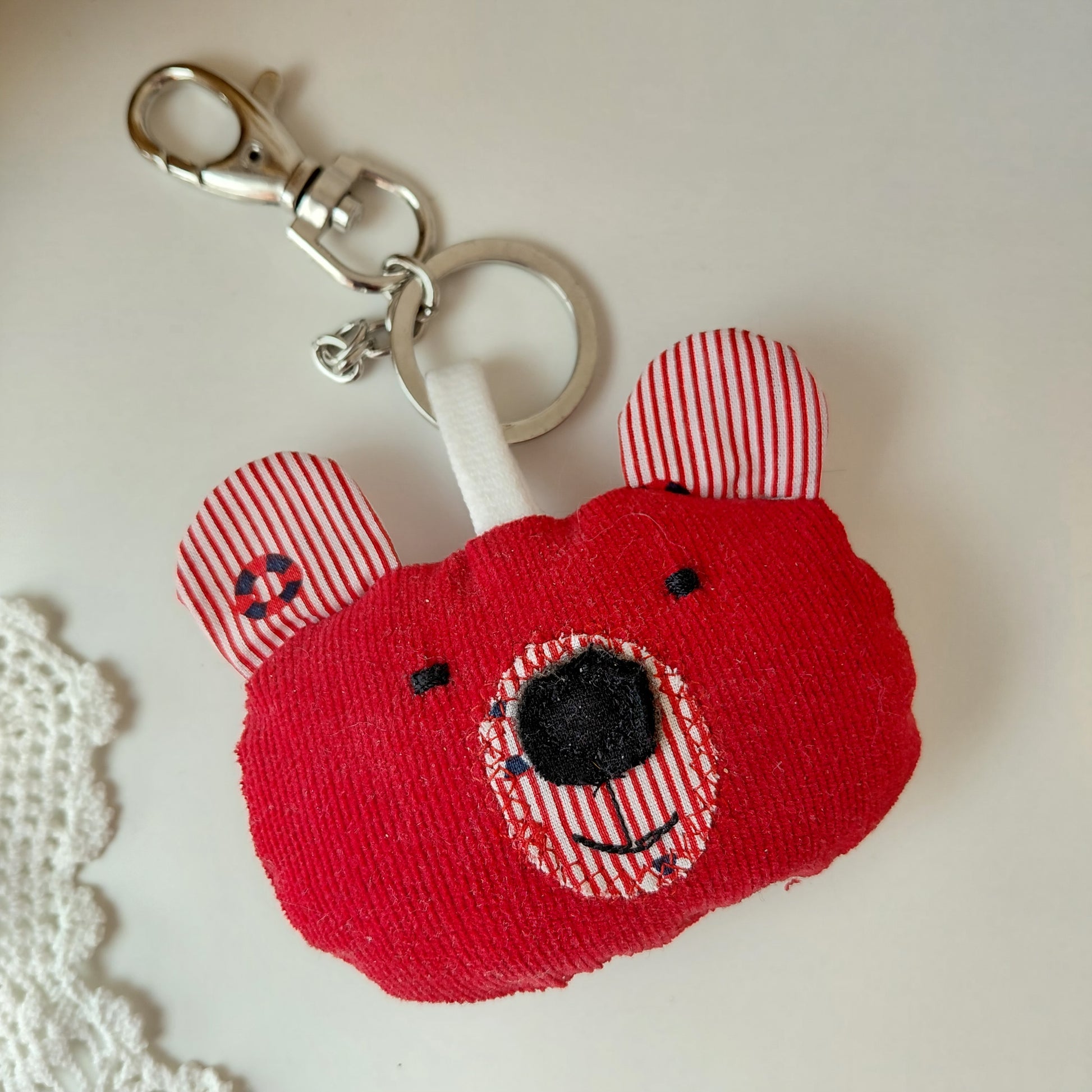 Red fabric keychain with a smiling face 