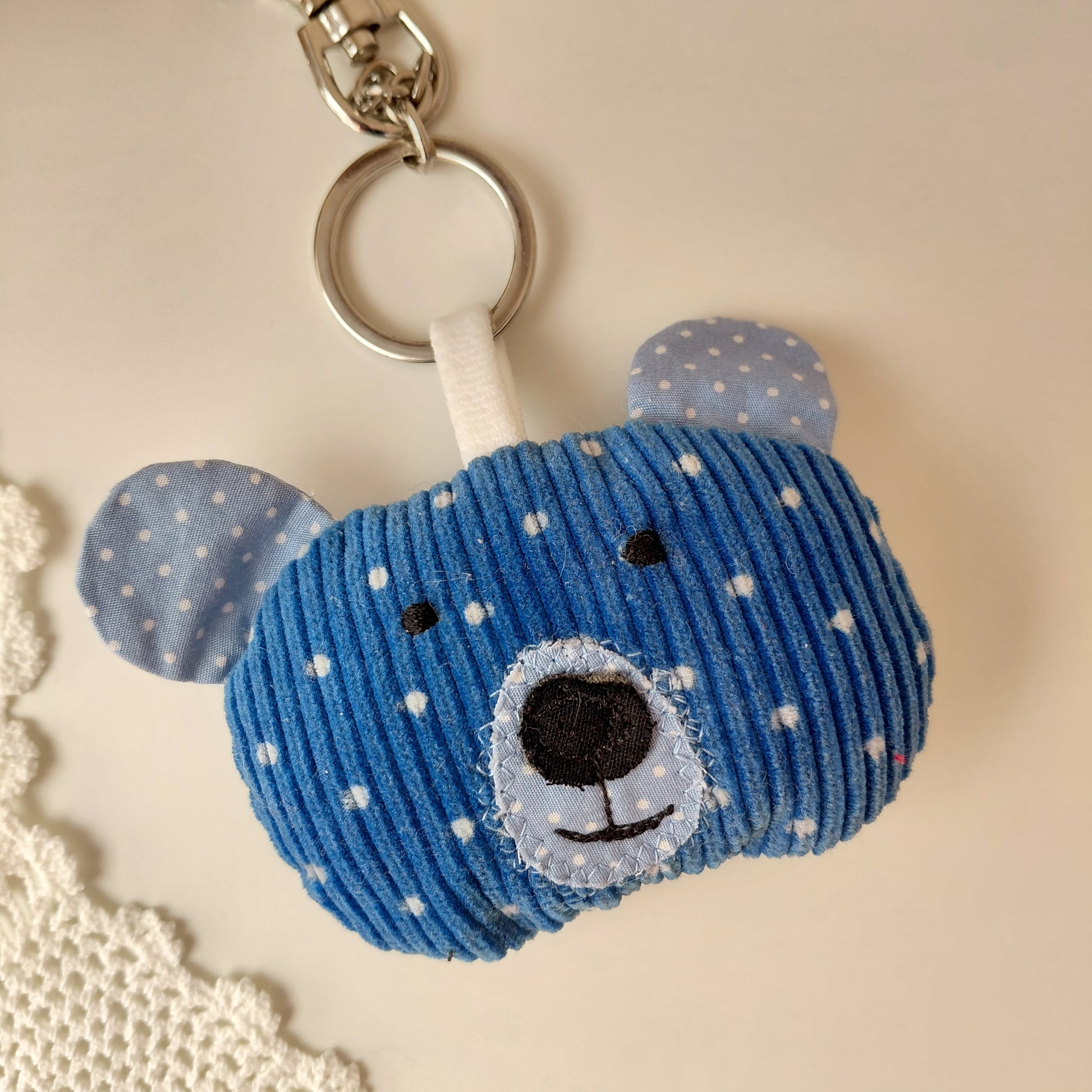 Blue bear-shaped keychain with white polka dots 