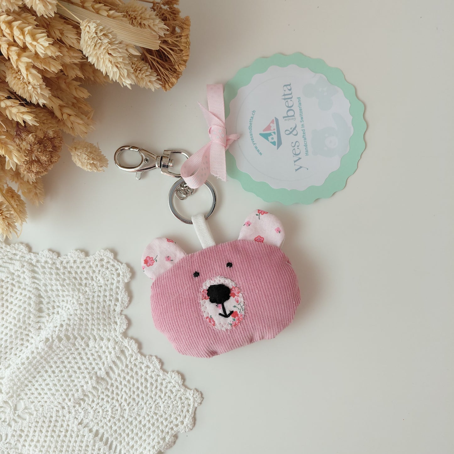 Pink bear-shaped keychain with a tag 