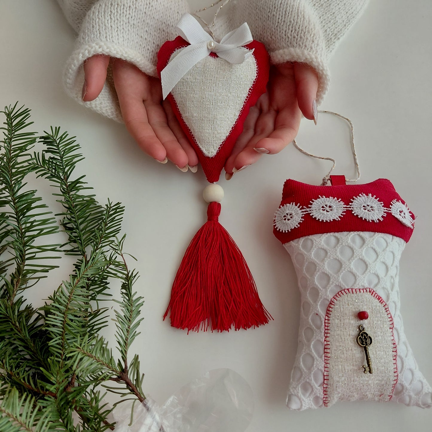 Heart-shaped red and white ornament held by a person with a decorative key 