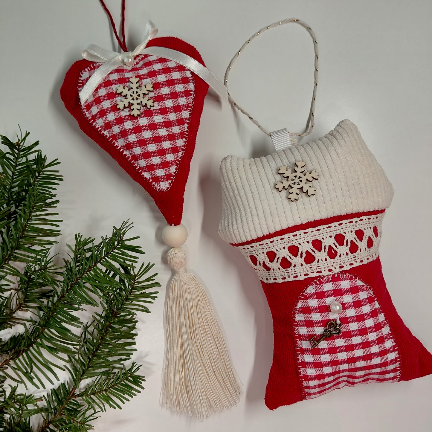 Two Christmas-themed fabric ornaments with a tassel and snowflake decorations
