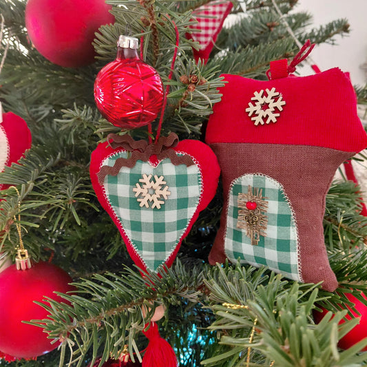 Decorative Christmas ornaments on a tree with red balls and green plaid patterns.